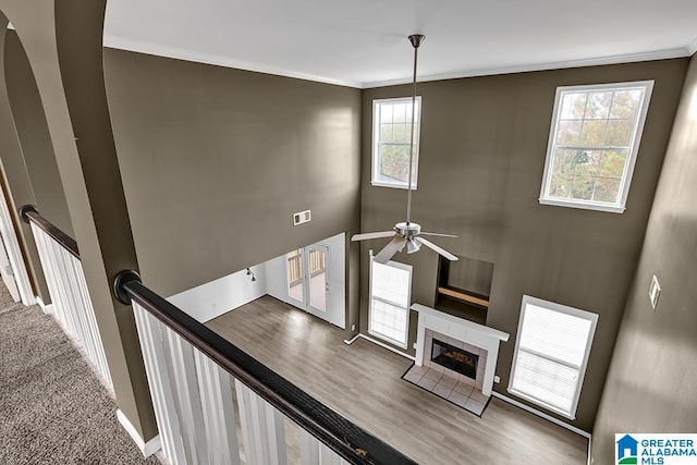 stairs with ornamental molding, hardwood / wood-style flooring, a fireplace, and ceiling fan