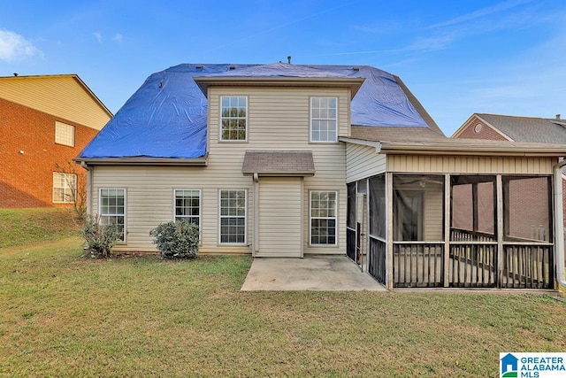 rear view of house featuring a yard, a patio, and a sunroom