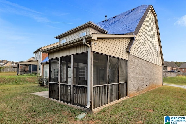 view of side of home featuring a yard and a sunroom