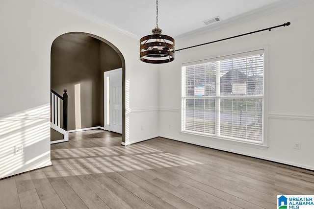 interior space with a notable chandelier, ornamental molding, and hardwood / wood-style floors