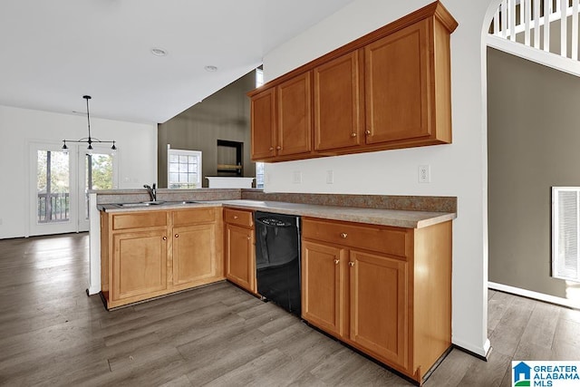 kitchen with black dishwasher, an inviting chandelier, light wood-type flooring, sink, and decorative light fixtures