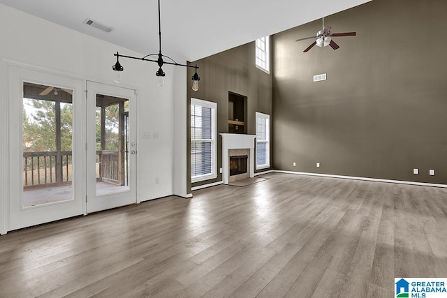 unfurnished living room featuring ceiling fan, high vaulted ceiling, and wood-type flooring