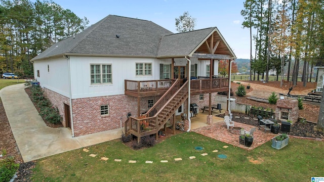 back of property with a wooden deck, a yard, and a patio