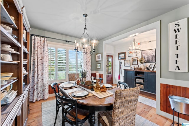 dining area with a notable chandelier and light hardwood / wood-style floors