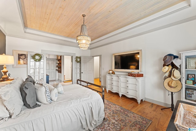 bedroom with wooden ceiling, ornamental molding, a notable chandelier, light wood-type flooring, and a raised ceiling