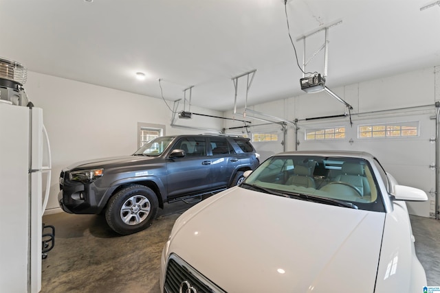 garage with a garage door opener and white fridge