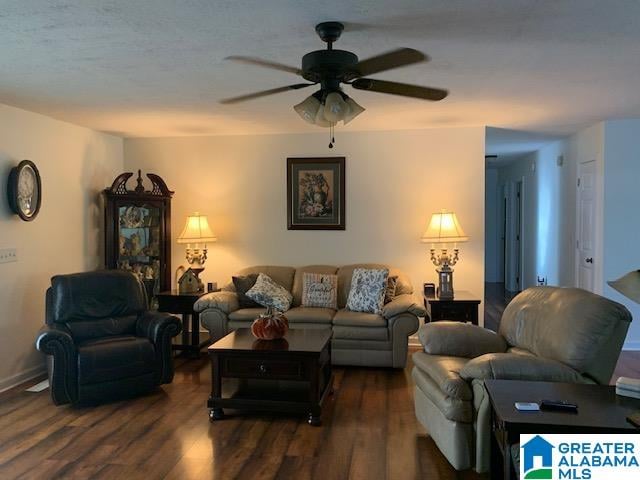 living room with dark hardwood / wood-style floors and ceiling fan