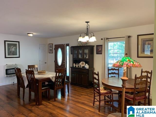 dining room with heating unit, an inviting chandelier, and dark hardwood / wood-style flooring