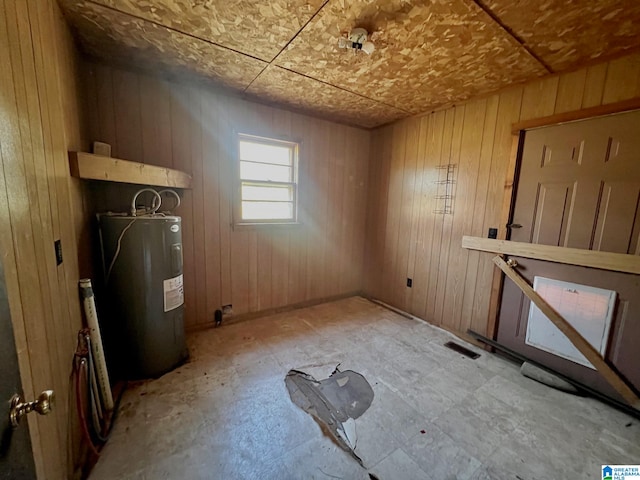 interior space with water heater and wooden walls