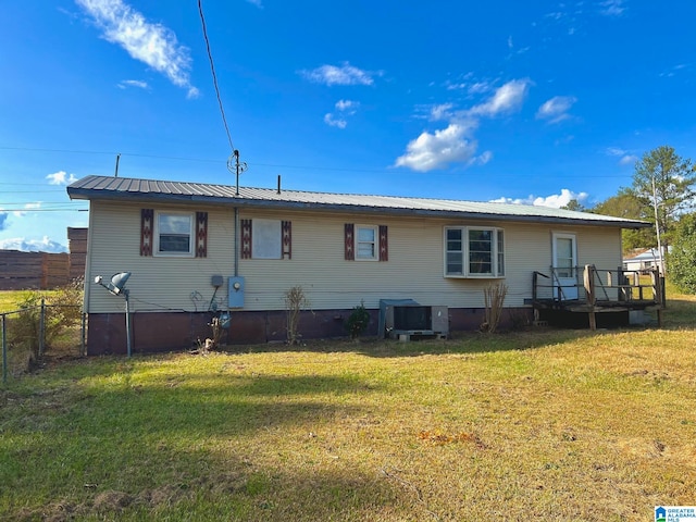 back of property featuring a deck and a lawn