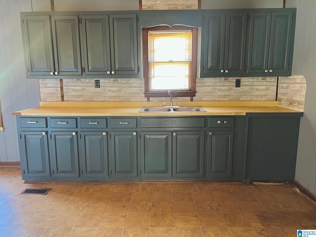 kitchen featuring wood walls, tasteful backsplash, and sink