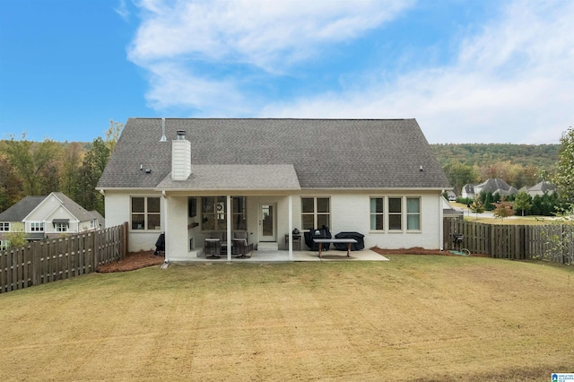 back of house featuring a patio area and a lawn