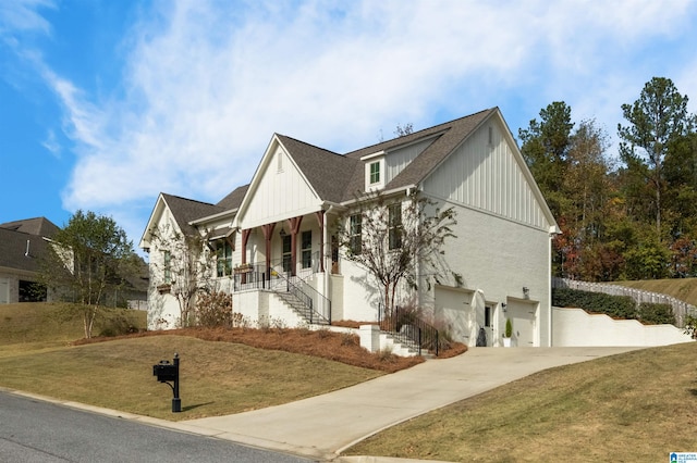 view of front of property with a garage, a front lawn, and a porch