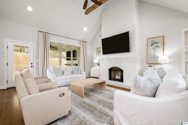 living room with a brick fireplace, hardwood / wood-style flooring, high vaulted ceiling, and ceiling fan