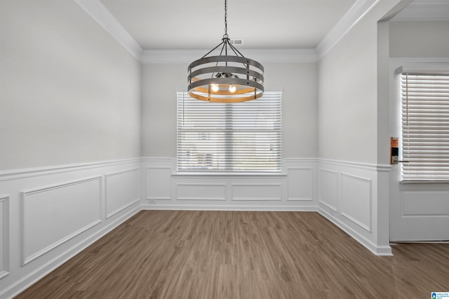 unfurnished dining area featuring a notable chandelier, crown molding, and dark wood-type flooring