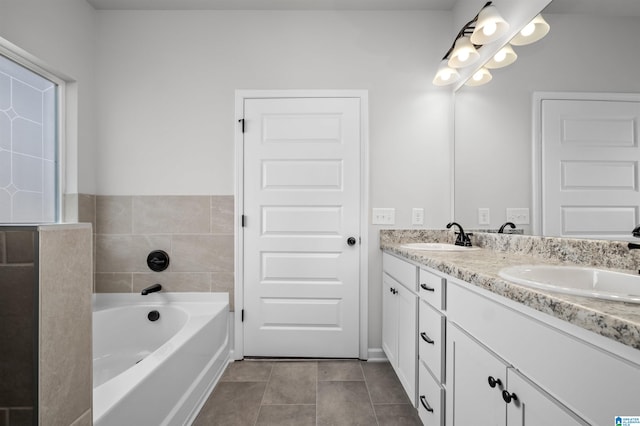 bathroom with tile patterned floors, a bathtub, and vanity