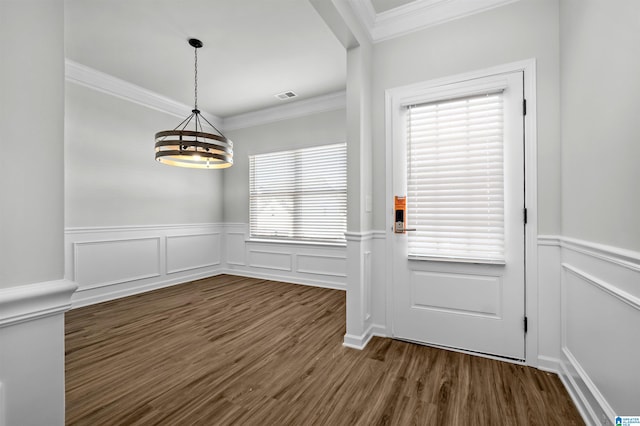 entryway with dark hardwood / wood-style floors, crown molding, and a chandelier