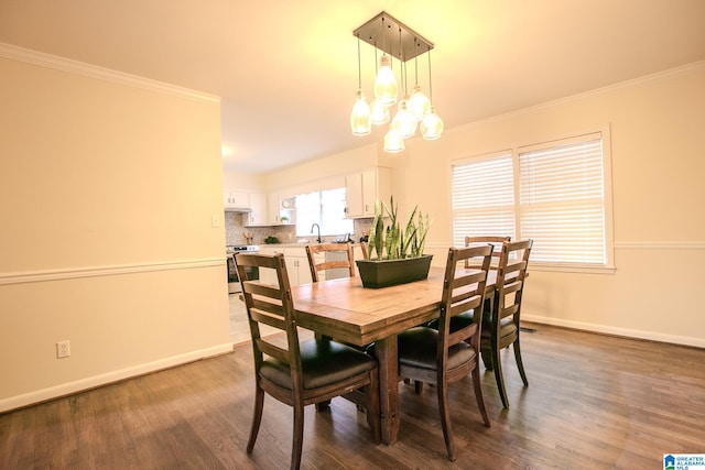 dining area featuring sink, crown molding, dark hardwood / wood-style flooring, and an inviting chandelier