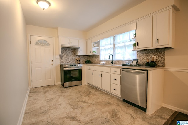 kitchen with stainless steel appliances, tasteful backsplash, sink, and white cabinets