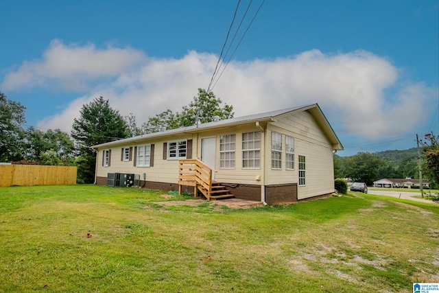 view of front of house featuring central AC and a front yard