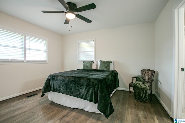 bedroom with dark wood-type flooring, ceiling fan, and multiple windows