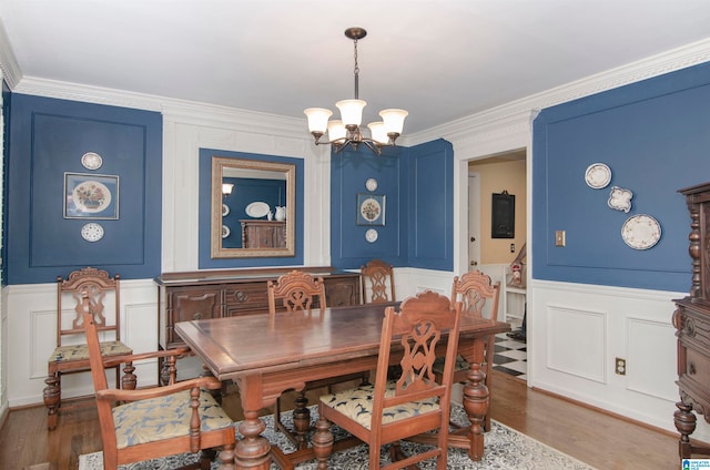 dining space with dark wood-type flooring, a notable chandelier, and ornamental molding