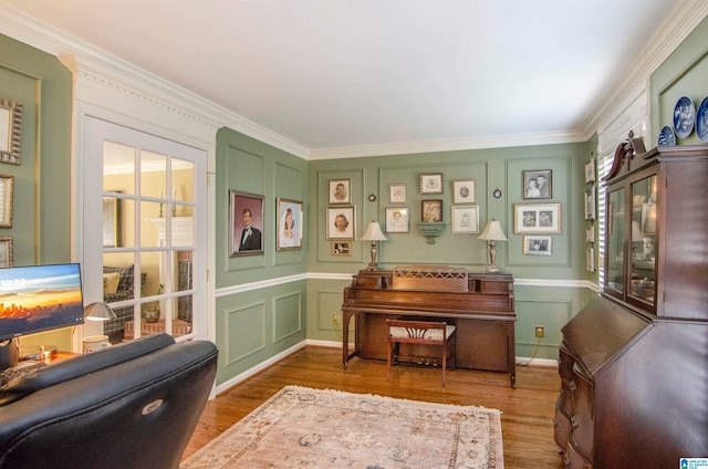 living area with ornamental molding and hardwood / wood-style floors