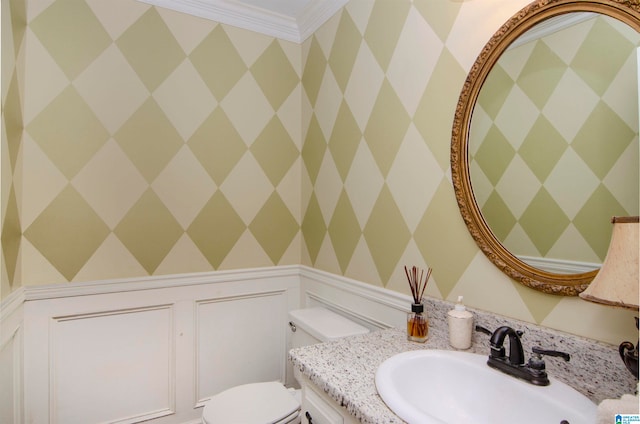 bathroom featuring vanity, toilet, and ornamental molding