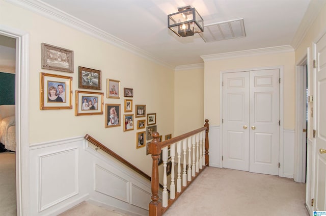 staircase with crown molding and carpet floors