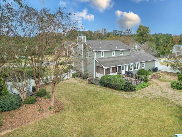 back of house featuring a wooden deck and a lawn