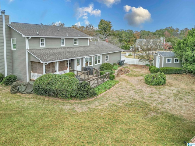 rear view of property featuring a deck and a lawn