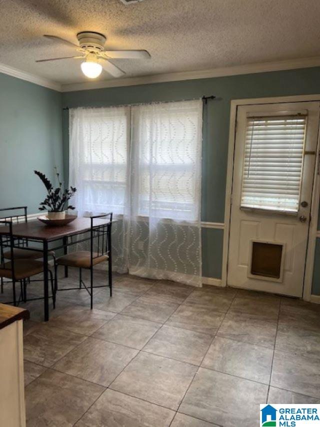 dining space featuring ceiling fan, crown molding, a textured ceiling, and plenty of natural light