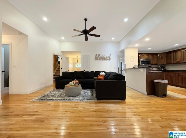 living room featuring light wood-type flooring and ceiling fan