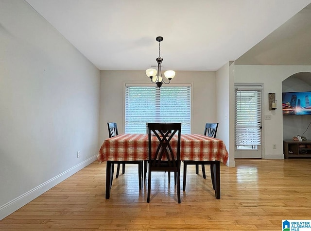 dining area with light hardwood / wood-style flooring and a notable chandelier