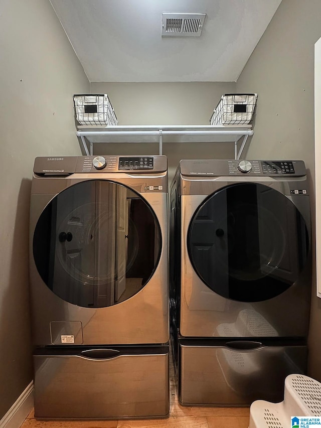 laundry area with washer and clothes dryer and light tile patterned flooring