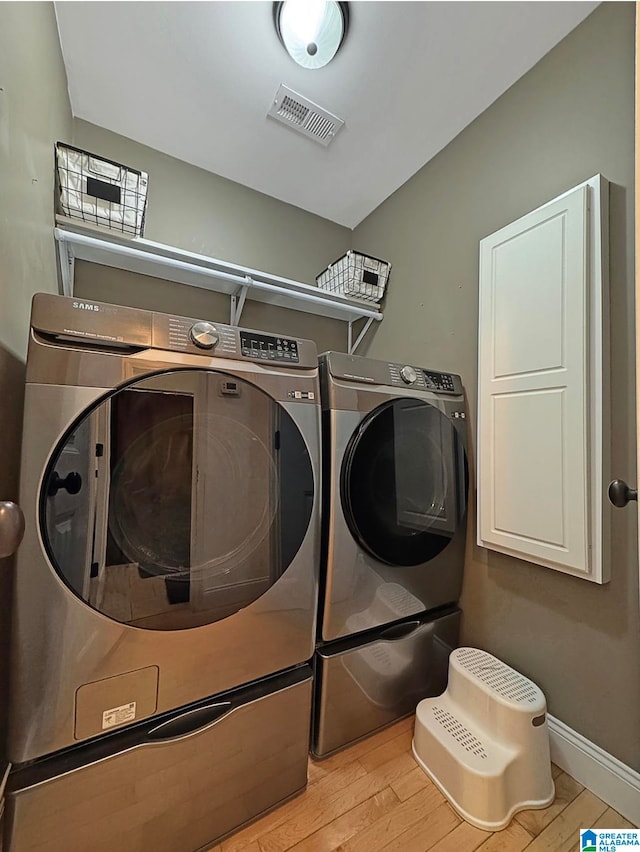 laundry room featuring light hardwood / wood-style floors and washer and clothes dryer