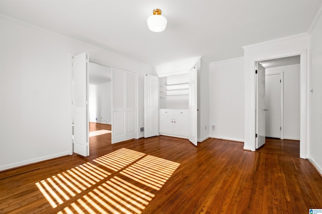 unfurnished bedroom featuring ornamental molding, dark hardwood / wood-style floors, and a closet