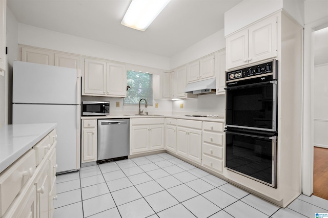 kitchen featuring light tile patterned floors, appliances with stainless steel finishes, sink, and white cabinets