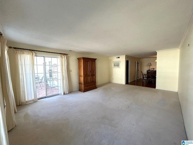 interior space with light carpet, a textured ceiling, and ornamental molding