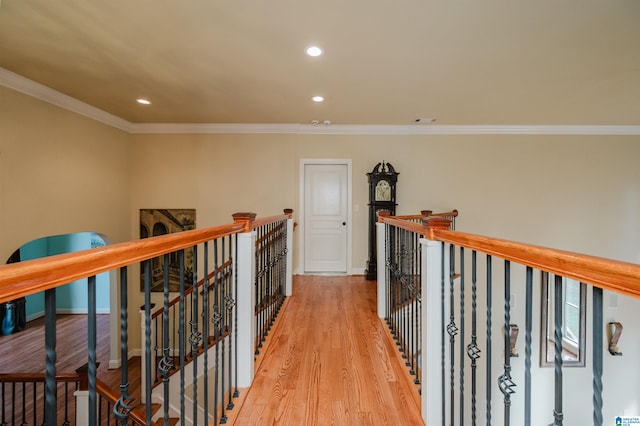 hall with ornamental molding and light hardwood / wood-style floors