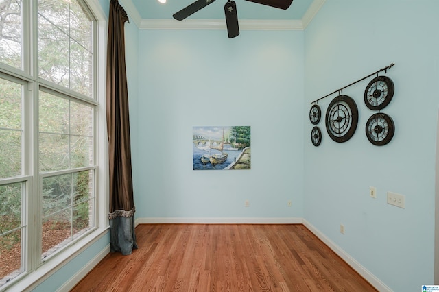 empty room with ceiling fan, crown molding, and light hardwood / wood-style flooring