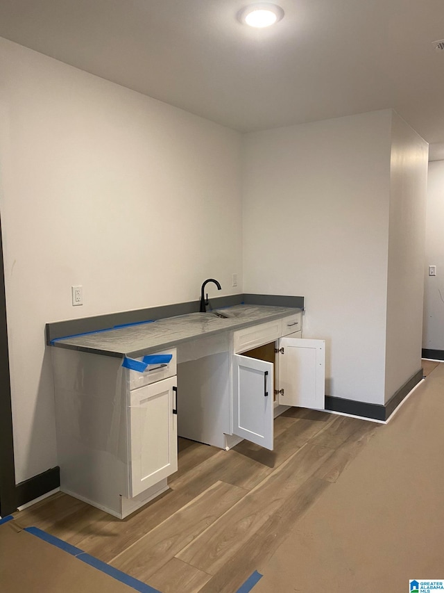 laundry area with light wood-type flooring