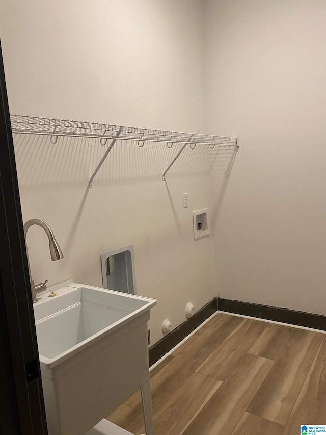 clothes washing area with gas dryer hookup, washer hookup, and wood-type flooring