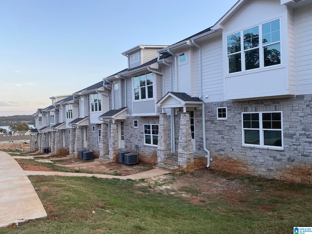 view of front of house featuring central AC and a lawn