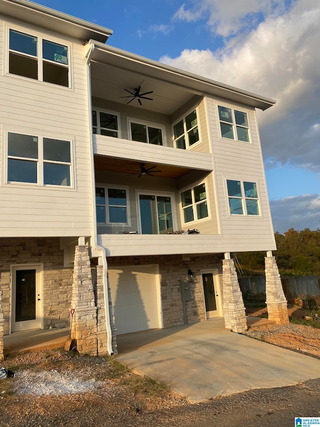 view of front of home featuring ceiling fan and a garage