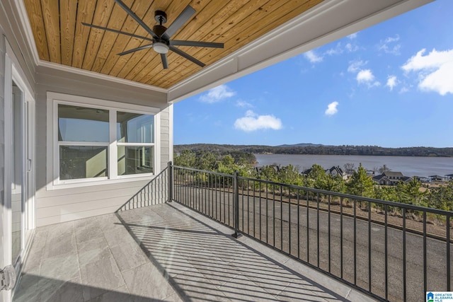 balcony with a water view and a ceiling fan