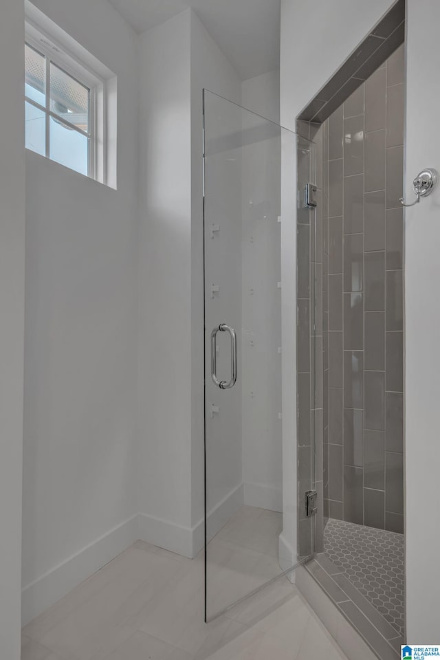 full bath with a shower stall and baseboards