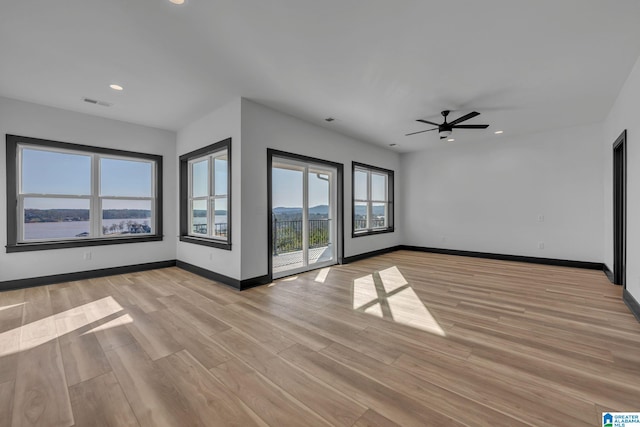 empty room with light wood finished floors, recessed lighting, visible vents, and baseboards