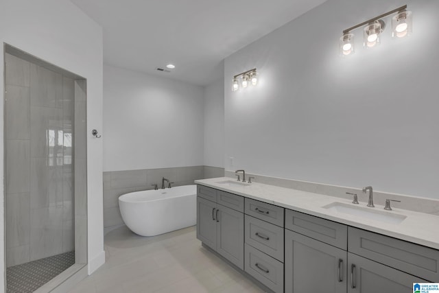 bathroom with visible vents, a sink, a freestanding bath, and a walk in shower