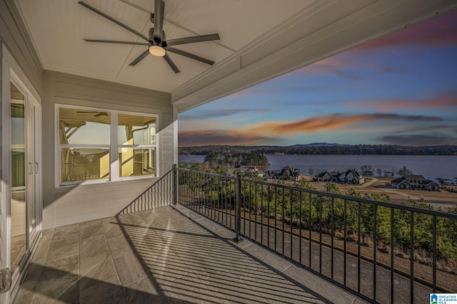 balcony featuring a water view and a ceiling fan